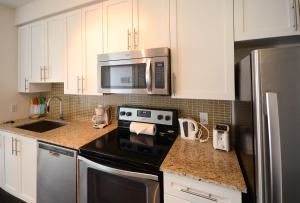 a kitchen with a stove and a microwave at Executive Furnished Properties - Square One Mississauga in Mississauga