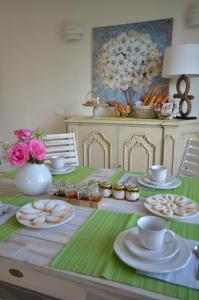 a table with plates of food and a vase with flowers at Villa Porto sul Magra in Ameglia +19 photos