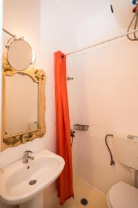 La salle de bains est pourvue d'un lavabo, d'un miroir et de toilettes. dans l'établissement Hotel Delphines, à Mykonos