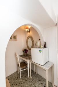 eine Küche mit einem Tisch und einem Kühlschrank in der Unterkunft Hotel Delphines in Mykonos Stadt