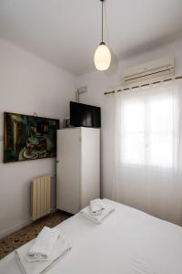 ein Schlafzimmer mit einem weißen Bett und einem Fenster in der Unterkunft Hotel Delphines in Mykonos Stadt
