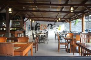 un restaurante con mesas y sillas de madera y un mural en Puri Senggigi Hotel, en Senggigi 