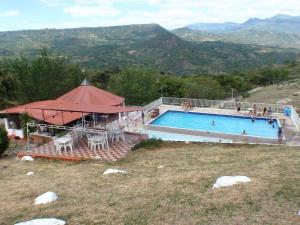 a swimming pool with a tent and people in it at Alojamiento Rural Gran Chaparral in El Colegio