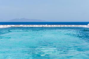 ein großer Körper aus blauem Wasser mit einem weißen Eisberg in der Unterkunft Blue Waves Suites & Apartments in Kamari