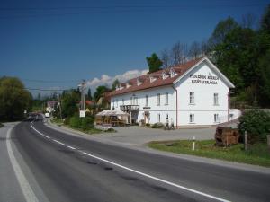 a white building on the side of a road at Penzión Kúria in Dolný Kubín
