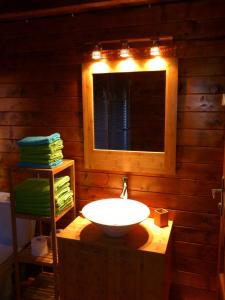 uma casa de banho com um lavatório, uma janela e toalhas em La Cabane du Raideur em Cilaos