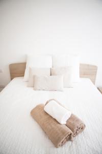 ein weißes Bett mit einem braunen Handtuch drauf in der Unterkunft Alessia's Flat - Buenos Aires in Mailand