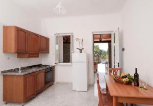 a kitchen with a table and a white refrigerator at Residence Le Vigne in Forio d'Ischia