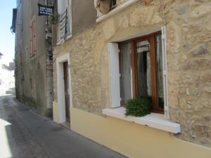 un edificio con una ventana con una maceta. en Chez Tania en Vallon-Pont-dʼArc