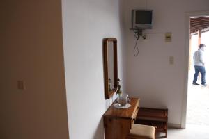 a room with a mirror and a table and a tv at Studios Angela Village in Leipsoi