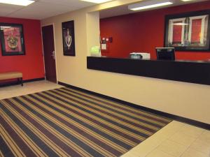 a lobby with a cash counter and red walls at Extended Stay America Suites - Rochester - Henrietta in Ridgeland