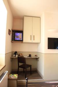 a kitchen with a table and a chair and a microwave at Albergo Benito in Norcia