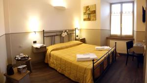 a bedroom with a bed with yellow sheets and a window at Albergo Benito in Norcia