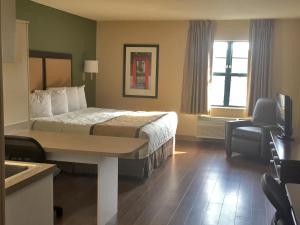 um quarto de hotel com uma cama e uma cadeira em Extended Stay America Suites - Chicago - Itasca em Itasca