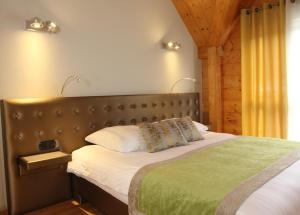 a bedroom with a large bed with a green blanket at Hôtel Restaurant Les Alisiers in Lapoutroie +51 photos