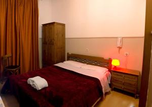 a bedroom with a bed and a dresser and a lamp at Argo in Thessaloniki