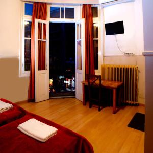een kamer met een bed, een bureau en een raam bij Argo in Thessaloniki