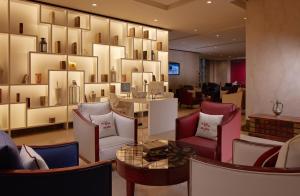 麥加的住宿－馬卡利姆烏姆奧庫拉酒店，一间设有椅子和一张桌子的房间和一面镜子