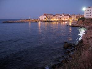 a large body of water at night with buildings at L' Escala Resort in L'Escala