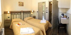 a hotel room with two beds with towels on them at Albergo Benito in Norcia
