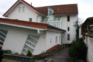 ein weißes Haus mit einer Garage und einem Gebäude in der Unterkunft Ferienwohnung Weinberg in Gründau