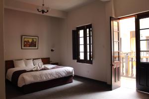 a bedroom with a bed and an open door at Colonial Plaza Hotel in Puno