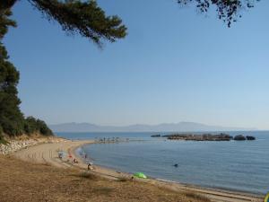 a beach with a bunch of people in the water at L' Escala Resort in L'Escala