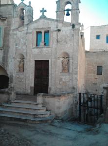 an old stone church with a door and stairs at Stone Rooms in Matera