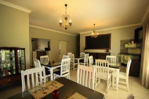 Un comedor con una mesa y sillas blancas. en La Rose Douglas Guesthouse No loadshedding, en Douglas