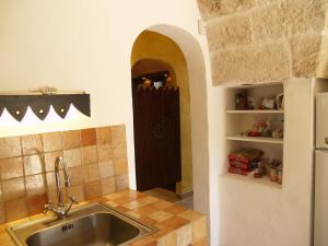 a kitchen with a sink and a kitchen with a door at Case d'Artista in Savelletri di Fasano