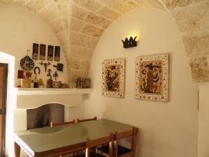 un comedor con una mesa y una corona en la pared en Case d'Artista, en Savelletri di Fasano