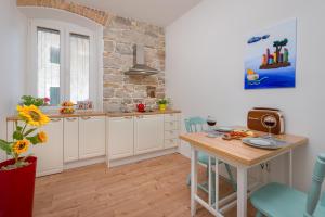 a kitchen with white cabinets and a wooden table at Luxury Boutique Apartment Stone Palace in Split