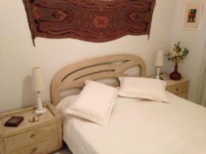 a bedroom with a white bed with two white pillows at Penedo Flats in Penedo