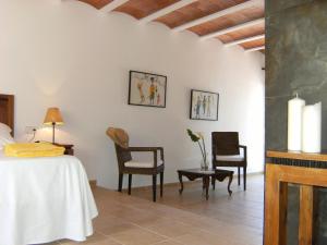 a bedroom with a bed and chairs in a room at Hotel Rural Can Maries in Puerto de San Miguel