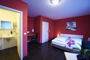 a bedroom with a bed and a bathroom with a sink at Hotel Dolce Vita in Bernkastel-Kues