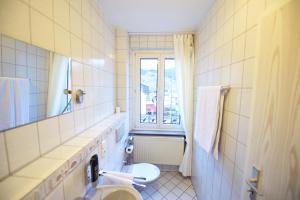 a bathroom with a toilet and a sink and a window at Hotel Dolce Vita in Bernkastel-Kues