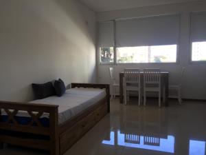 1 dormitorio con 1 cama, mesa y sillas en Alvarado 50 en Bahía Blanca