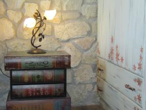 a lamp on a stack of books next to a stone wall at Villa Lydia in Meganisi