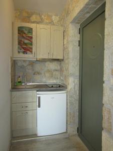 a small kitchen with a white refrigerator in a room at Villa Lydia in Meganisi