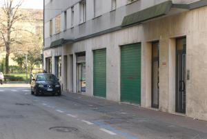 samochód zaparkowany przed budynkiem z zielonymi drzwiami garażowymi w obiekcie Apartment Podgora 13 w Mestre