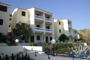 an apartment building with white walls and a fence at Hotel Priscapac Resort & Apartments in Prizba