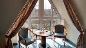 a room with a table and two chairs and a window at City Hotel Aschersleben in Aschersleben