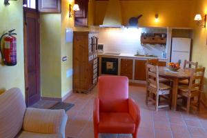 a kitchen with a table and a red chair at Casa Rural El Hondillo in Valverde