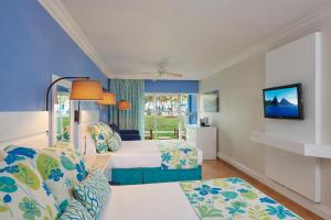 Rúm í herbergi á Coconut Bay Beach Resort & Spa All Inclusive