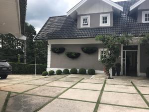 Una casa con dos plantas a un lado. en Vila de Charme Suítes, en Campos do Jordão