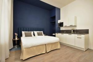 a bedroom with a large bed and a blue wall at Alveo Suites in Prague