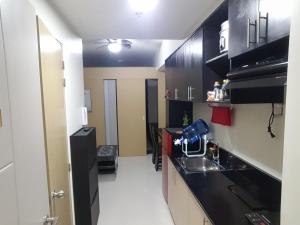 uma cozinha com armários pretos e um balcão preto em Suite 16 em Tagaytay