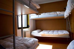 a room with two bunk beds and a window at Albergue Montes de Anaga in El Bailadero