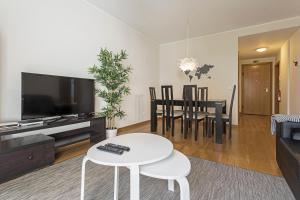 a living room with a television and a table and chairs at Pena I by An Island Apart in Funchal