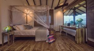 a bedroom with a canopy bed and a desk at C Beyond Nilaveli in Nilaveli